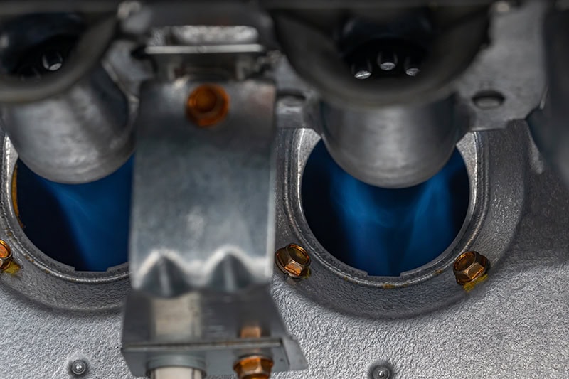 10 Things to Consider When Buying a New Furnace. Close up photo of a gas furnace flame burner.